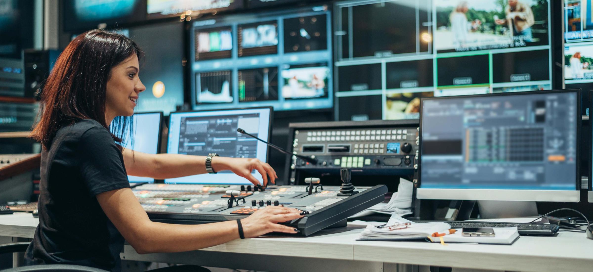 2022_Jonge vrouw die werkt in een controlekamer voor uitzendingen op een tv-station_S_2061306392 2022_Jonge vrouw die werkt in een controlekamer voor uitzendingen op een tv-station_S_2061306392