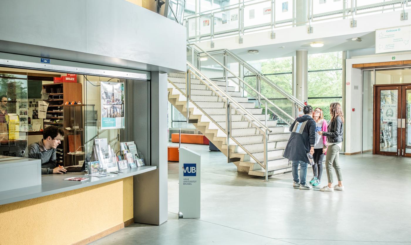 Groep van studenten aan het praten voor het infopunt van Campus Etterbeek