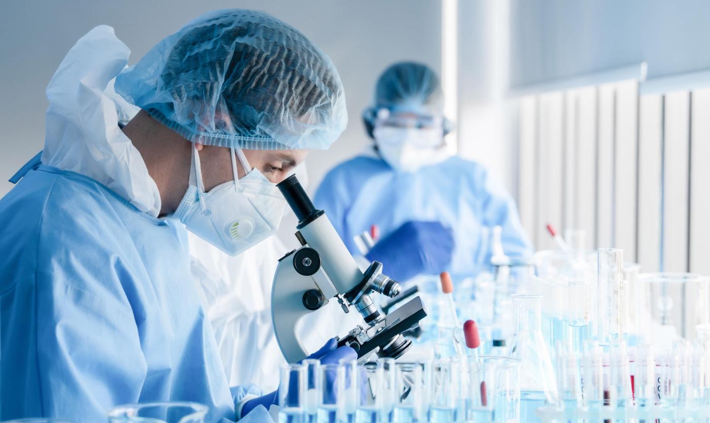 Onderzoeker werkt met microscoop in een onderzoekslaboratorium 2022_Biochemisch onderzoeksteam werkt met microscoop_Farmaceutisch onderzoekslaboratorium_S_1726134715