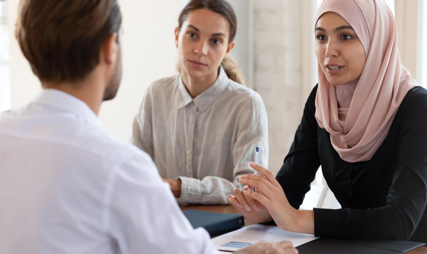 2022_Etnische zakenvrouw draagt hijab in een vergadering met haar collega's_S_1536232361.jpg
