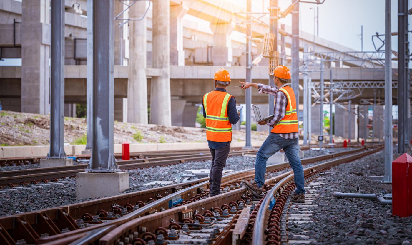 2022_Ingenieur draagt veiligheidsuniform en veiligheidshelm op het spoorwegstation_S_1812749569