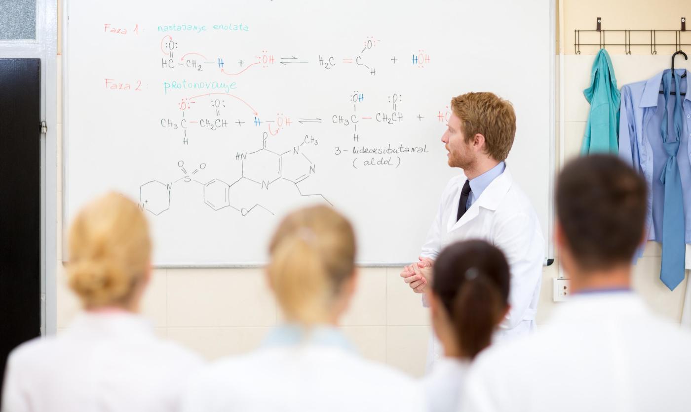 2022_Jonge mannelijke scheikundige leraar geeft les aan studenten in de klas_Klaslokaal_S_333563855 2022_Jonge mannelijke scheikundige leraar geeft les aan studenten in de klas_Klaslokaal_S_333563855