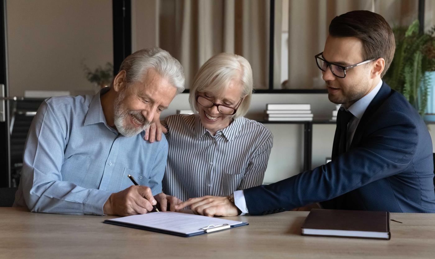 2022_Sluitingsovereenkomst_Gelukkige tevreden echtgenoot en vrouw gepensioneerden zetten hun eigen handtekeningen onder het contract_S_2063156012