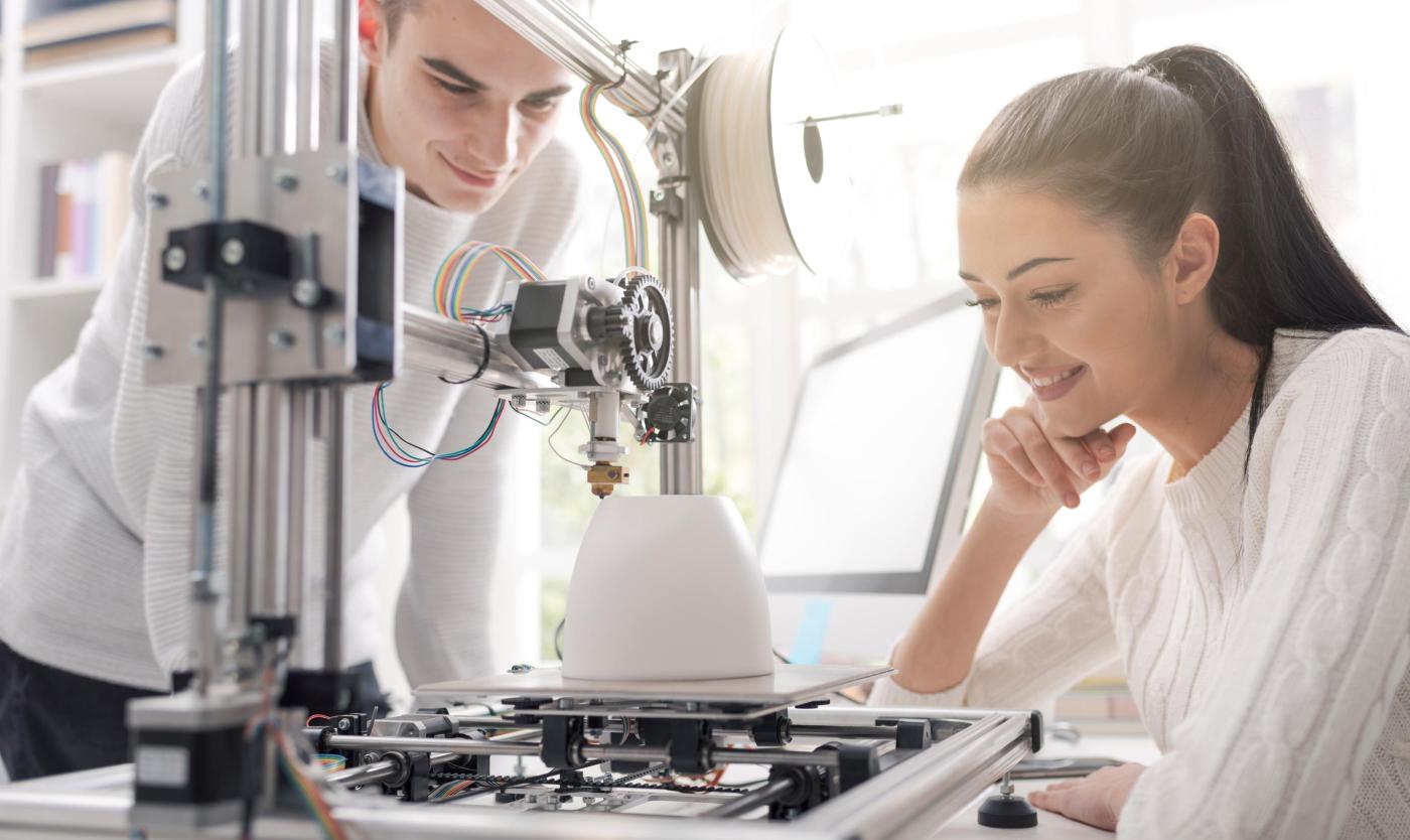 2022_Student en studente kijken naar een 3D-Printer_Fablab_S_1290546448