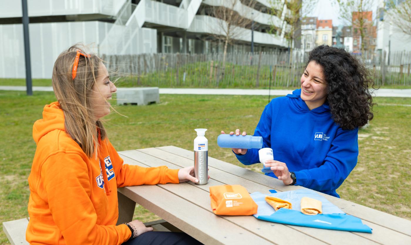 2021_Meisjes buiten aan een tafel met merchandise van de webwinkel_Webshop_Gadgets_VUB 2021_Meisjes buiten aan een tafel met merchandise van de webwinkel_Webshop_Gadgets_VUB
