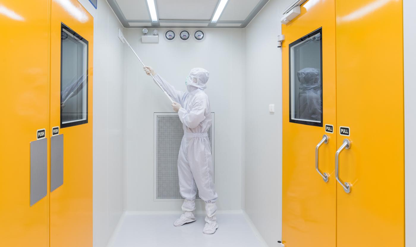 Onderzoeker in beschermend pak in cleanroom