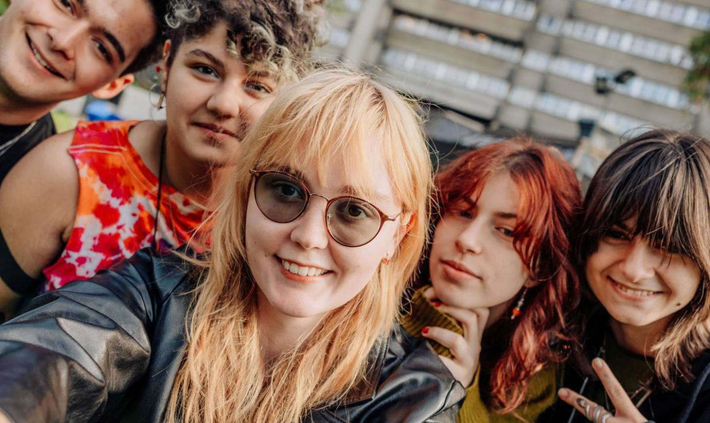 Studenten nemen selfie op campus in Etterbeek met gebouwen Esplanade op de achtergrond