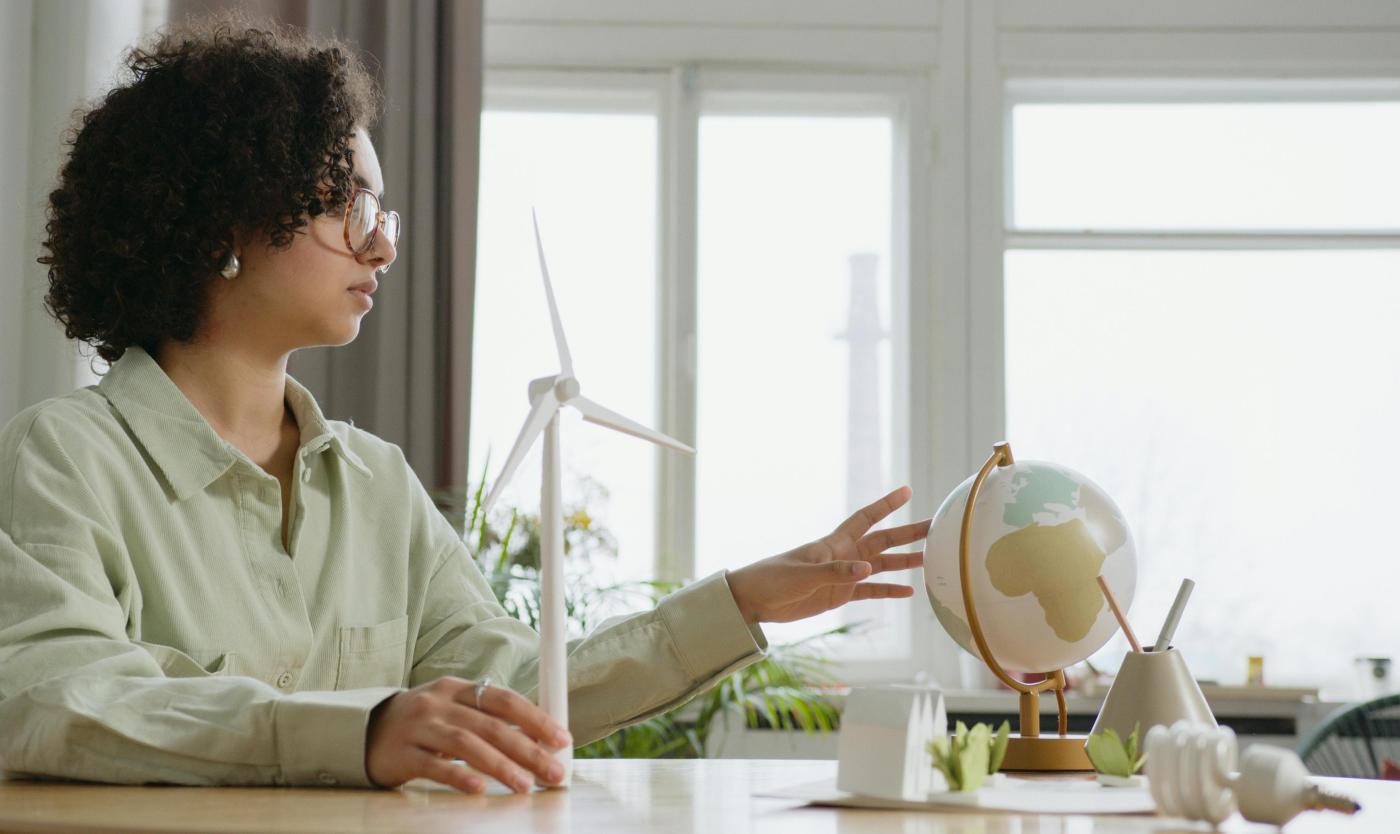 Vrouw met miniatuur windmolen en wereldbol