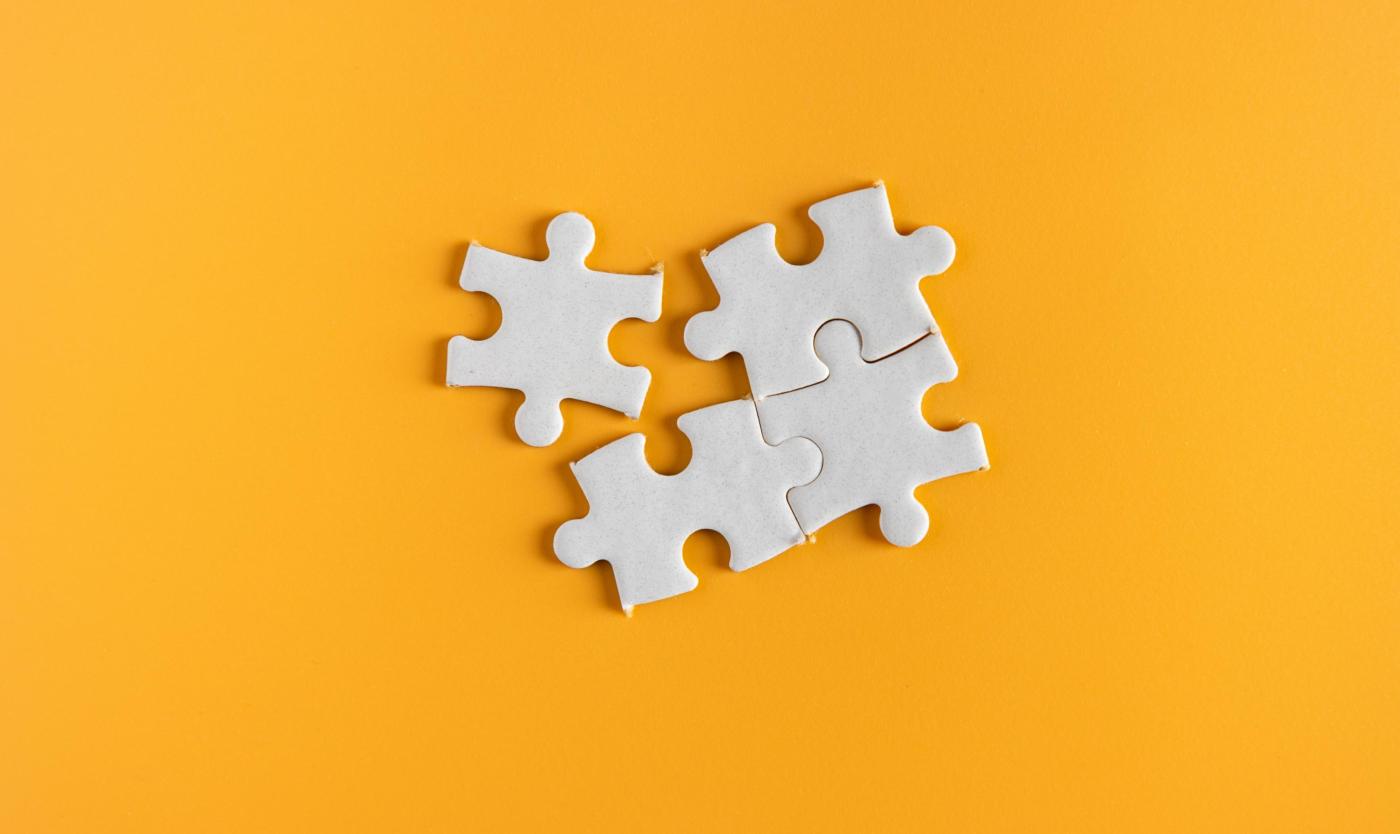 Witte puzzelstukjes op een oranje achtergrond