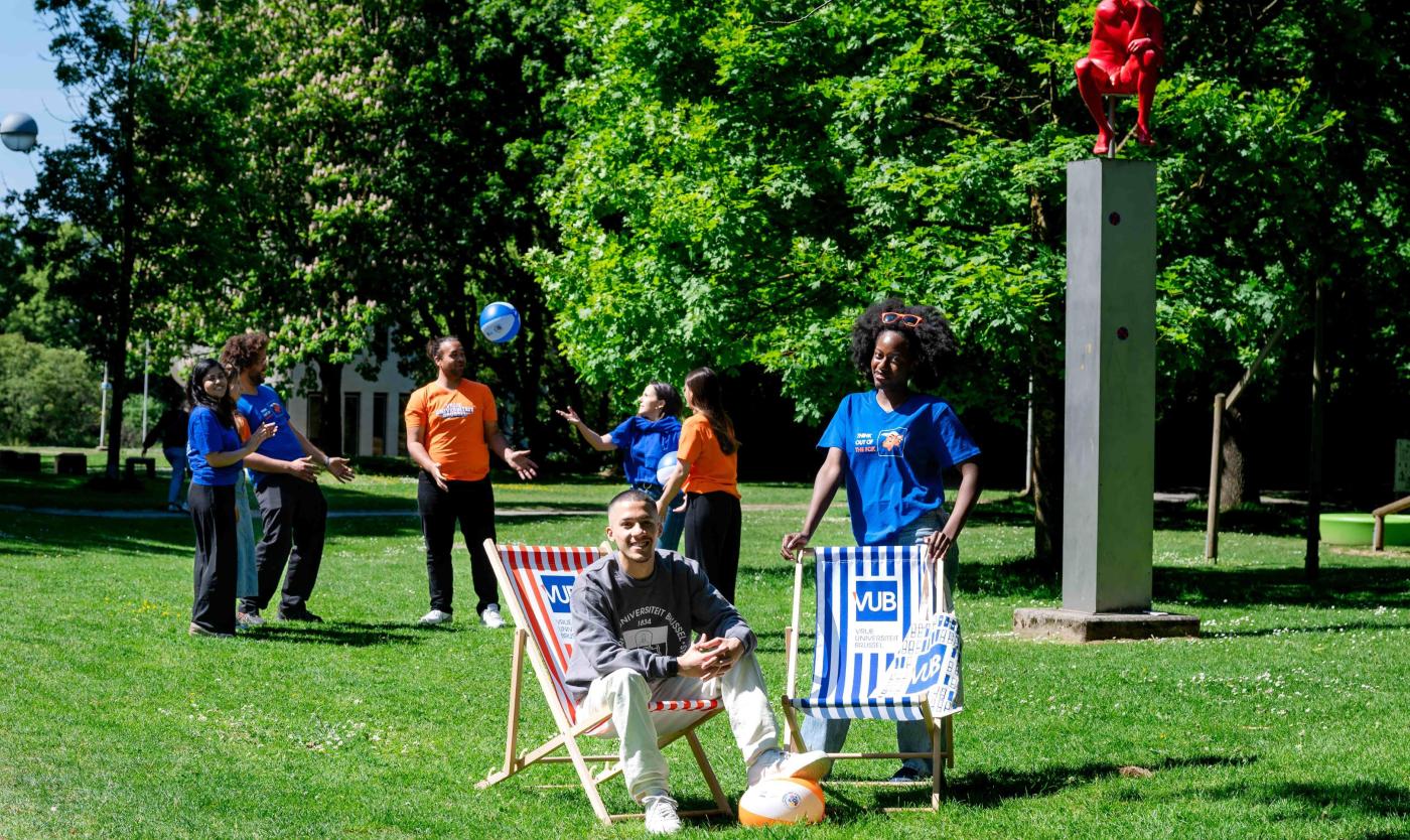 Studenten poseren met webshopproducten naast de denker op de campus in Etterbeek