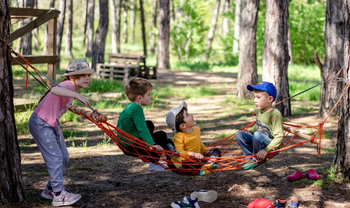 Kinderen op hangmat in bos