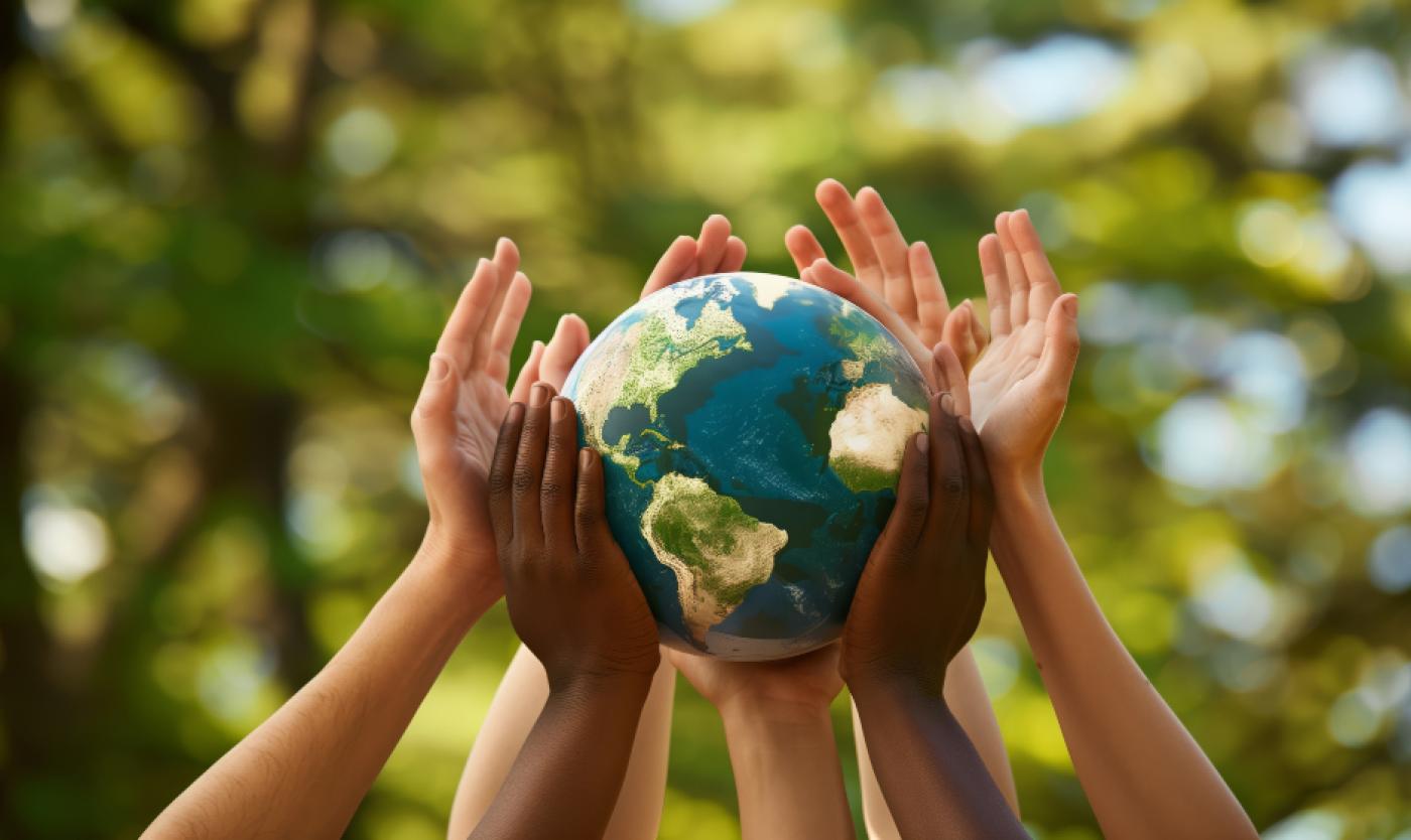 Multiple hands holding up a globe