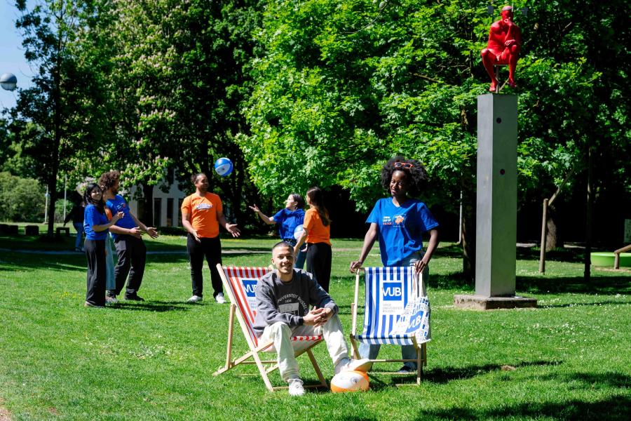 Studenten poseren met webshopproducten naast de denker op de campus in Etterbeek