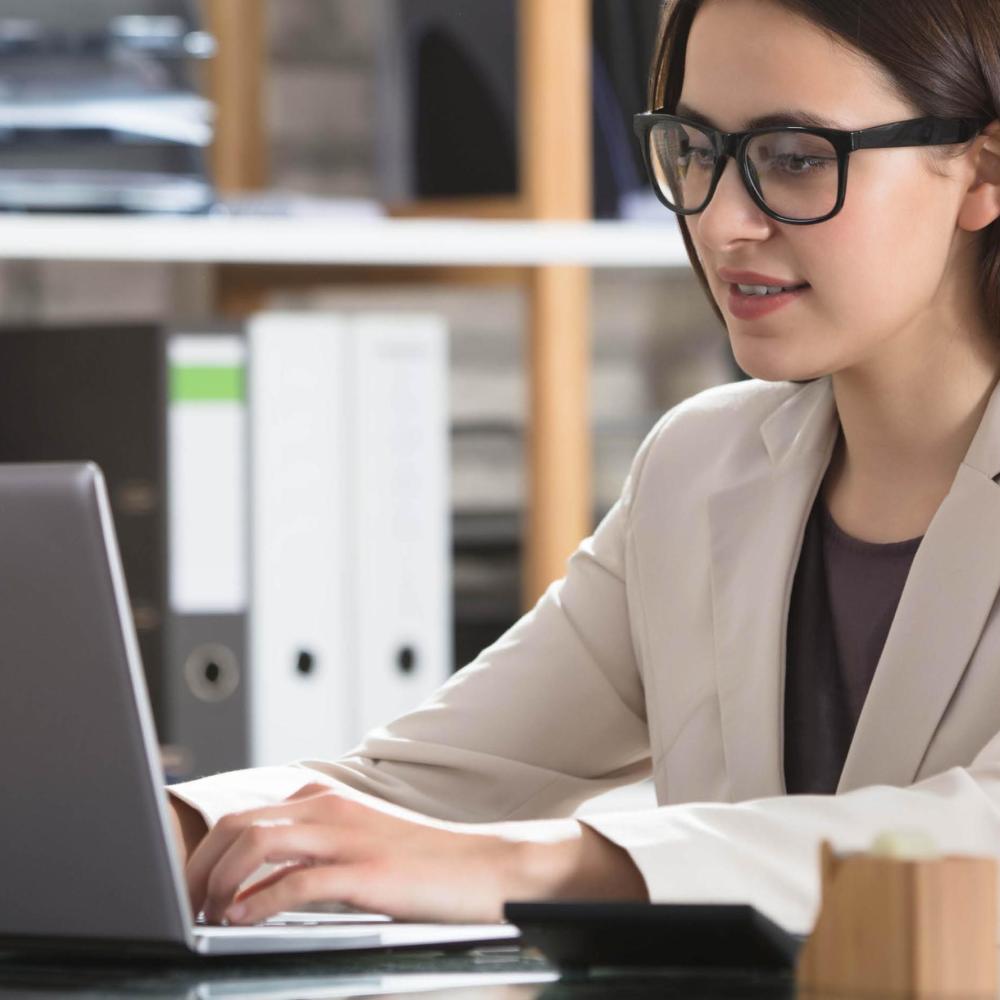 Vrouw werkend op haar laptop aan haar bureau