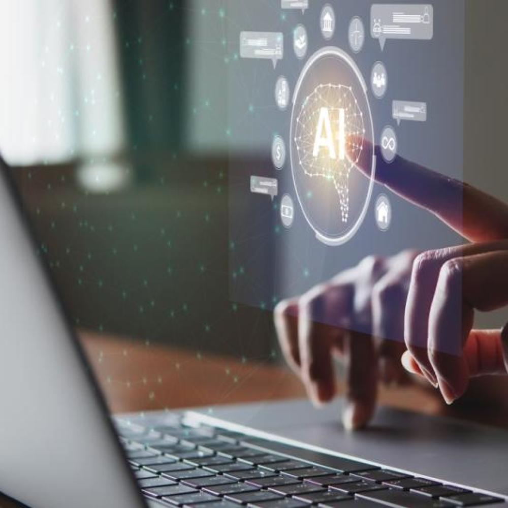 hands typing on laptop, touching AI in circle