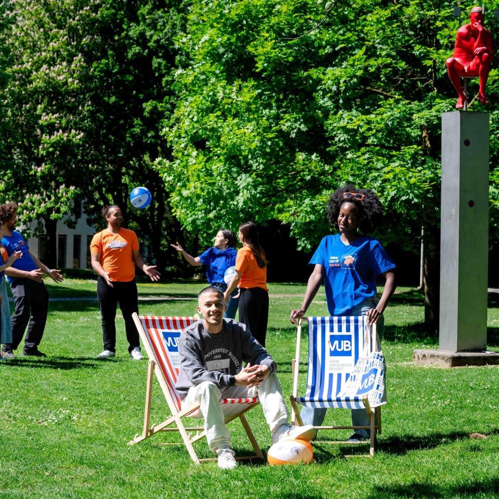 Studenten poseren met webshopproducten naast de denker op de campus in Etterbeek