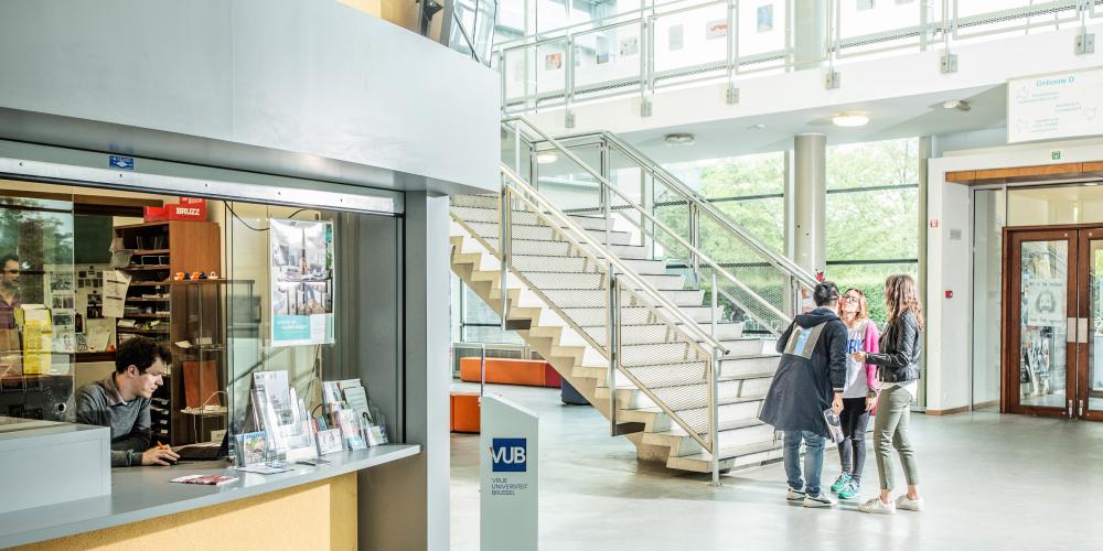 Groep van studenten aan het praten voor het infopunt van Campus Etterbeek