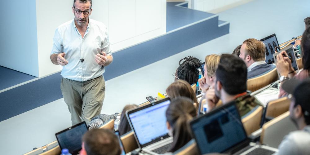 Professo aan het praten tegen studenten tijdens les in een aula van het Gebouw I op Campus Etterbeek