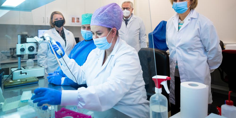 Onderzoekers in labo met microscoop voor Wereld Kankerdags bij UZ (Universitair Ziekenhuis Brussel)