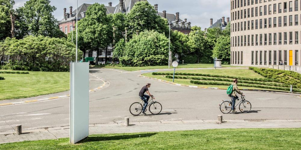 2022_Living Campus Walk_Koning fiets_Twee mannen op de fiets aan het Braemgebouw_Etterbeek_VUB 2022_Living Campus Walk_Koning fiets_Twee mannen op de fiets aan het Braemgebouw_Etterbeek_VUB