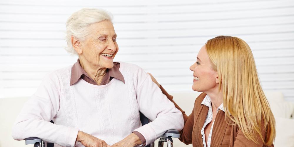 2022_Zorgverlener vrouw praten met senior burger in een rolstoel thuis_S_170076530