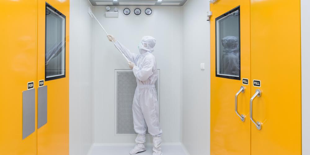 Onderzoeker in beschermend pak in cleanroom