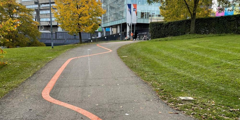 Campagnebeeld voor campagne tegen Grensoverschrijdend gedrag Oranje streep op het pad naar de Esplanade op Campus Etterbeek