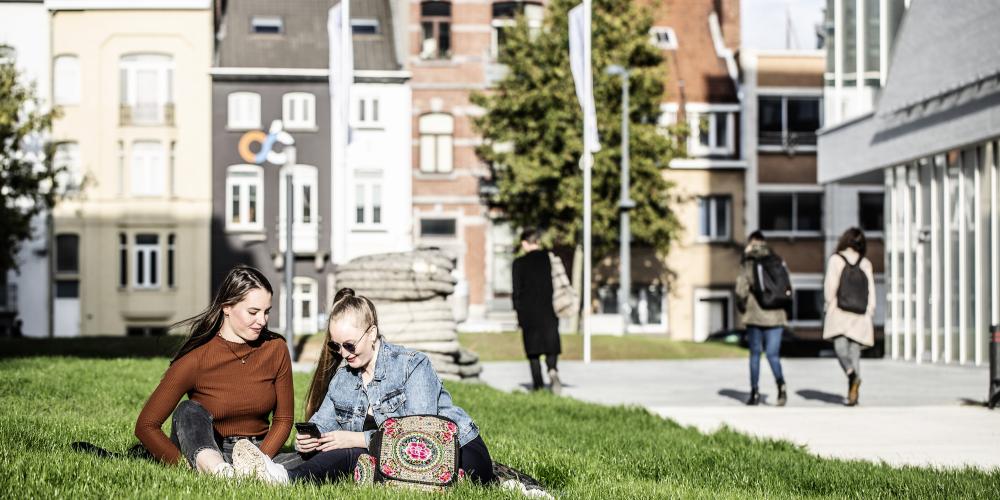 Studenten aan IXY gebouwen Studenten zitten op gras aan de IXY gebouwen op campus Etterbeek