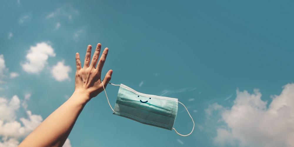 Persoon gooit mondmasker weg