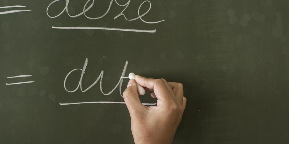 Hand schrijft op bord