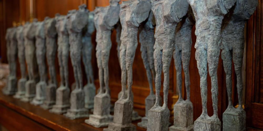 elke nieuwe fellow kreeg een kleine versie van Enkidu, het bronzen beeld dat voor het rectoraatsgebouw staat, gemaakt door kunstenaar Paul Van Gysegem. 