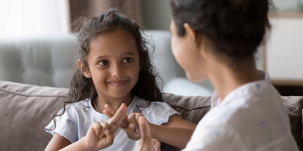 Kind spreekt gebarentaal Kind spreekt gebarentaal met moeder