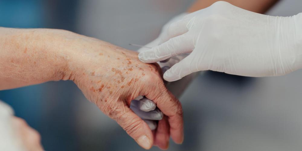 Close-up van verpleegkundige toediening van medicatie door middel van injectie