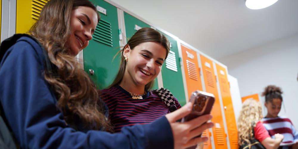 Lachende meisjes op smartphone